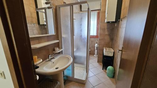 a small bathroom with a shower and a sink at Villaggio Tirreno appartamento 02 in Rosolina Mare