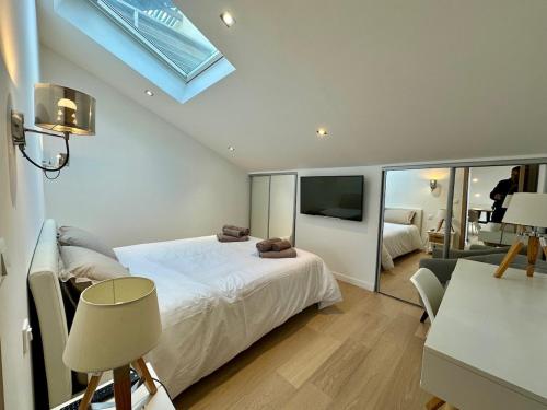 une chambre avec un lit blanc et une télévision dans l'établissement Gorgeous 2 bedrooms brand new sea view, à Antibes