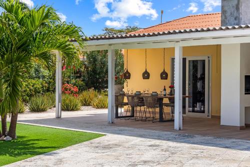 an outdoor patio with a table and chairs at Kas di Rosa Curacao luxurious holiday home in Grote Berg