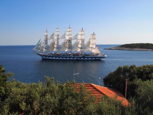 a large ship with white sails in the water at Hvar Dream View Penthouse with Hot Tub in Hvar