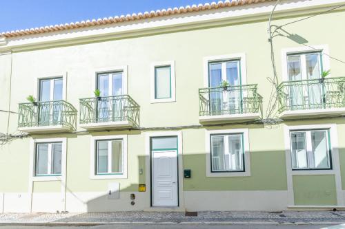 an apartment building with balconies and a door at Roots Apartments in Faro