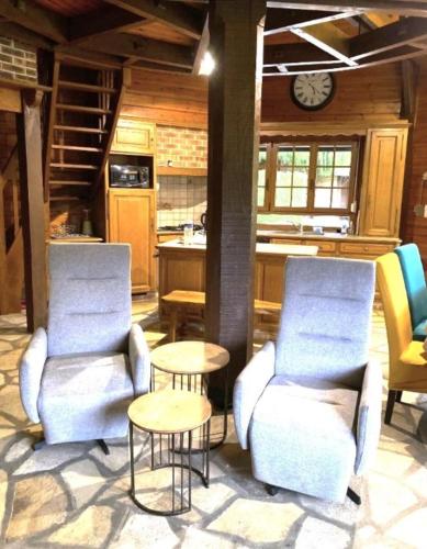 une cuisine avec deux chaises, une table et une horloge dans l'établissement Le coin de paradis, à Bouvellemont