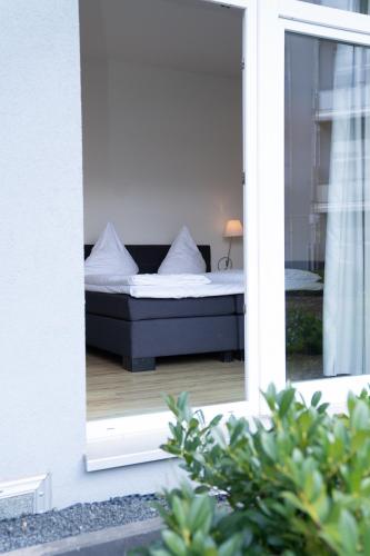 a bedroom with a bed seen through a mirror at Das Loft Apartments in Aachen