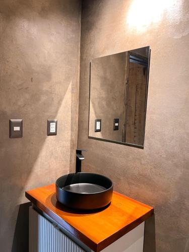a bathroom with a black sink on a wooden counter at Apartamento campestre 2 dormitorios con terraza in Puerto Varas