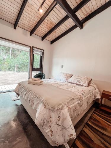 a bedroom with a large bed and a large window at Apartamento campestre 2 dormitorios con terraza in Puerto Varas