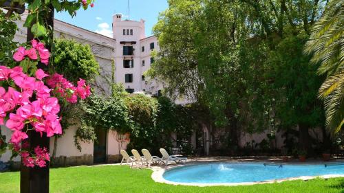 a courtyard with a pool and chairs and a building at Hotel Salta in Salta