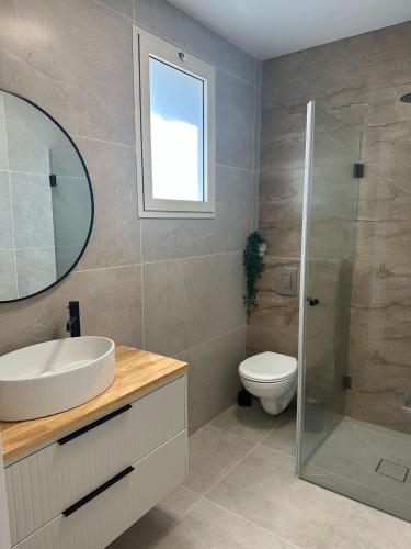 a bathroom with a sink and a toilet and a mirror at Ocean view - מול הים in Nahariyya