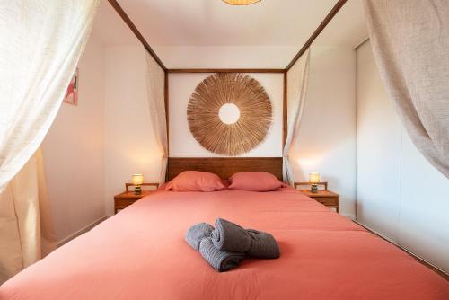 a bedroom with a bed with two towels on it at Oasis Cachée - Jacuzzi et cinéma in Toulouse