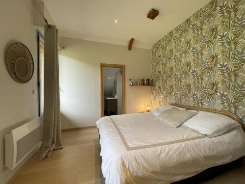 a bedroom with a large bed with a floral wall at Lou maval in Aydius