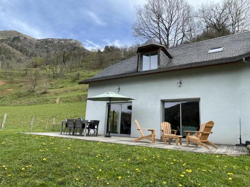 a white house with a patio with a table and chairs at Lou maval in Aydius