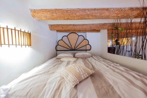 une chambre avec un grand lit avec un plafond en bois dans l'établissement Casa Phocea, à Marseille
