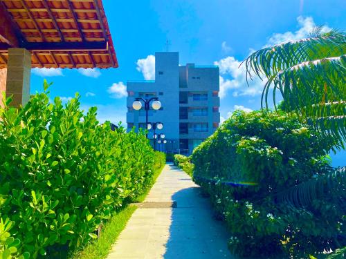 a pathway through a resort with a building in the background at Flat premium centro de Porto de Galinhas-Makambira Residence-Flat309 in Porto De Galinhas