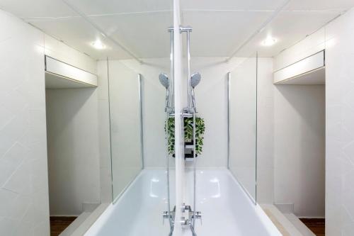 La salle de bains blanche est pourvue d'une baignoire avec une plante. dans l'établissement Casa Phocea, à Marseille