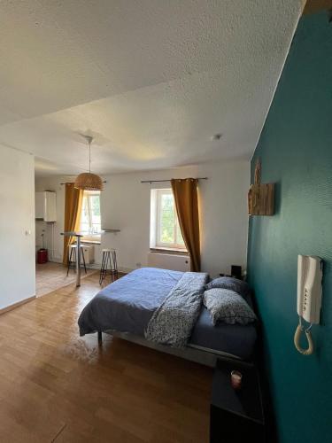 une chambre avec un lit et un mur bleu dans l'établissement TORINO - Appartement cozy, à Sarrebourg