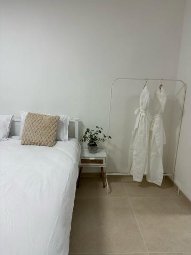 a bedroom with a bed with white sheets and a side table at Ocean view - מול הים in Nahariyya