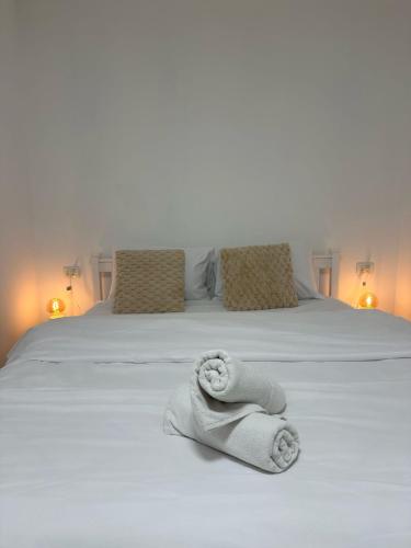 a white bed with towels on it with two pillows at Ocean view - מול הים in Nahariyya