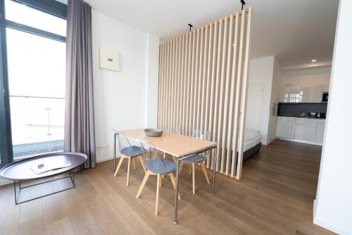 a room with a table and chairs and a bed at Das Loft Apartments in Aachen