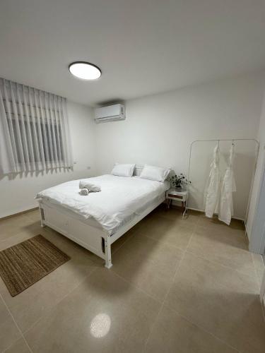 a bedroom with a white bed in a room at Ocean view - מול הים in Nahariyya