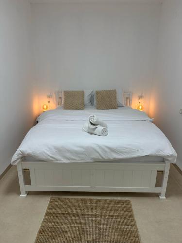 a bedroom with a white bed with two lamps at Ocean view - מול הים in Nahariyya