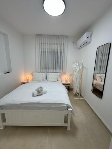 a bedroom with a white bed and a window at Ocean view - מול הים in Nahariyya