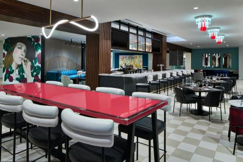 a restaurant with a red table and black chairs at Hotel Celare, Cincinnati Midtown, a Tribute Portfolio Hotel in Cincinnati