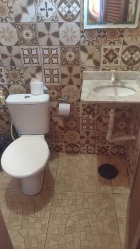 a bathroom with a toilet and a sink at Casa do Edi in Maricá