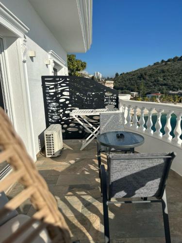 a patio with a table and chairs on a balcony at Luxury Villa Alisja Sarande with Private Beach in Sarandë