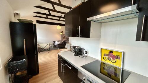 une cuisine avec des armoires noires et un comptoir blanc dans l'établissement Le Crotoy et moi, au Crotoy