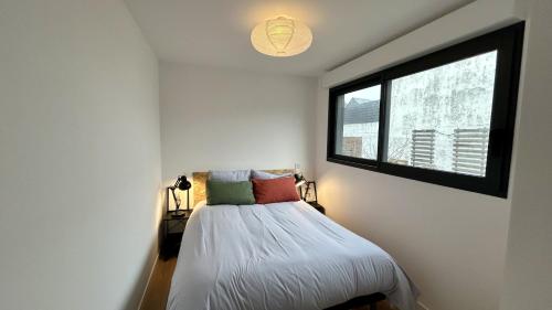 - une petite chambre avec un lit et une fenêtre dans l'établissement Le Crotoy et moi, au Crotoy