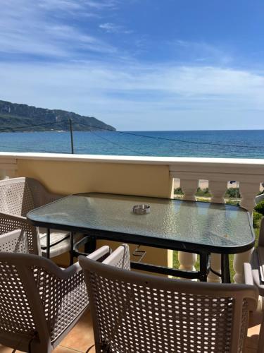 a table on a balcony with a view of the ocean at SAN GEORGE COVE in Afionas