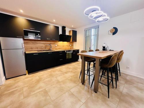 une cuisine avec une table et un réfrigérateur dans l'établissement Le PRESTIGE du SANCTUAIRE, à Lourdes