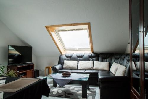 FriedenweilerにあるFerienwohnung am Waldrandのリビングルーム(革張りのソファ、窓付)