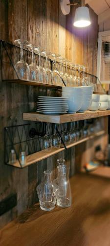 une étagère avec des verres, des assiettes et des bols dans l'établissement 4 Cabanes de luxe privatisées à 300m de la Dune, à La Teste-de-Buch