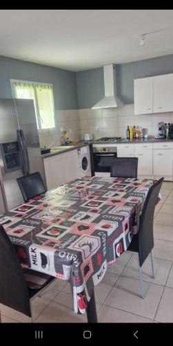 une cuisine avec une table et un tissu de table à motifs dans l'établissement La maison la calade, à Frontignan