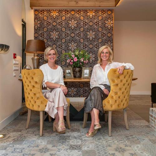 two women sitting in chairs in a room at KerkHotel Biervliet in Biervliet