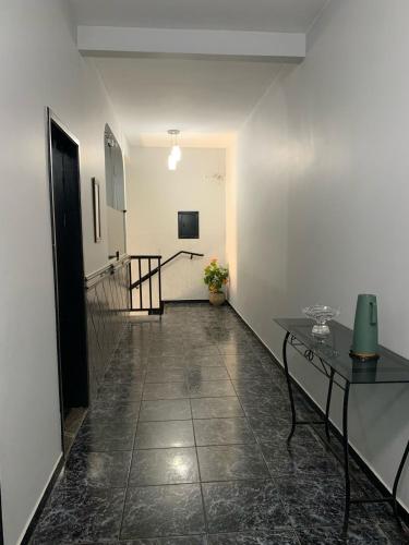 a hallway with a table and a stair case at Hotel Londres - taguatinga in Brasilia