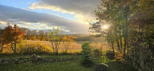 a view of a field with the sun in the sky at Beechwood Lodge in Alness