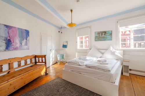 a white bedroom with a bed and a desk at Stilhaus 1730 in Königsbach Stein