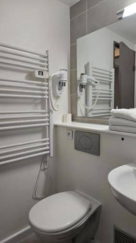 une salle de bain blanche avec des toilettes et un lavabo dans l'établissement Kyriad Fontenay - Trésigny, à Fontenay-Trésigny