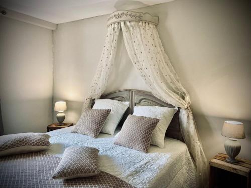 - une chambre avec un lit à baldaquin et des oreillers dans l'établissement Le Cottage du Brask, à La Motte-du-Caire