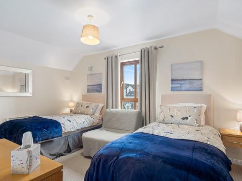 a bedroom with two beds and a window at The Courtyard Escape in Clifden