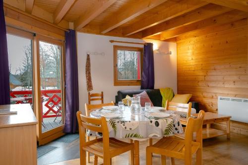 une salle à manger avec une table et des chaises dans l'établissement Chalet 228 - Village nordique, à Les Déserts