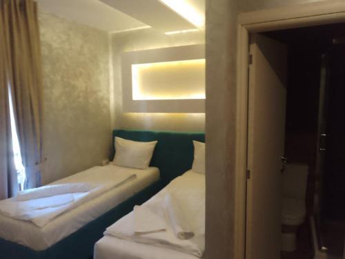 a small room with two beds and a window at Hotel Konačište Akustik in Zlatibor