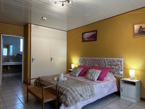 a bedroom with a large bed with pink pillows at Oasis Des Corbières in Boutenac