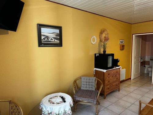 a living room with a tv and a chair and a table at Oasis Des Corbières in Boutenac