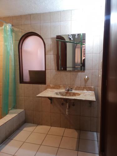 a bathroom with a sink and a mirror at La Casa Junto Al Rio in Arequipa