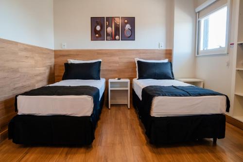 a room with two beds and a table in it at i5 Hotel Águas Claras in Brasilia