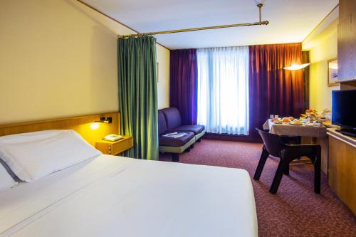 a hotel room with a bed and a desk at Hotel Les Jumeaux Courmayeur in Courmayeur