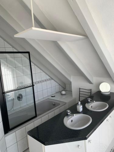 a bathroom with two sinks and a bath tub at Au Petit Bonheur in Thannenkirch