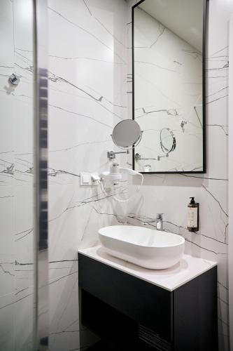 a white bathroom with a sink and a mirror at Forrest in Głogów Małopolski